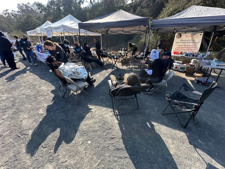 group receiving NADA acupuncture treatment in an open-air clinic